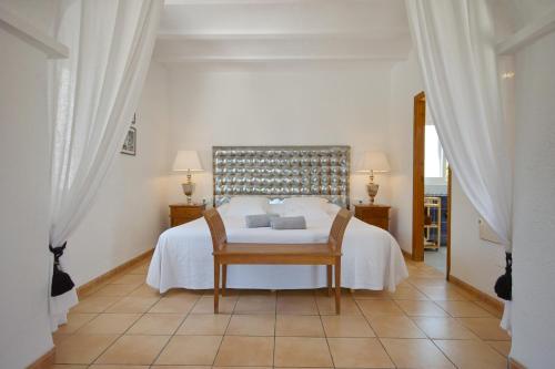 ein Schlafzimmer mit einem weißen Bett und einem Stuhl in der Unterkunft Hotel Rural Can Maries in Puerto de San Miguel
