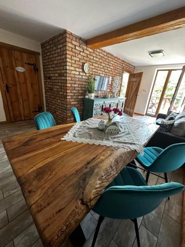 a dining room with a wooden table and blue chairs at Kaszubskie Zacisze in Chmielno