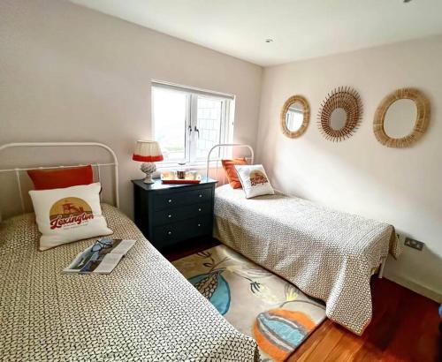 2 camas en un dormitorio con espejos en la pared en Number 9, Port Isaac Bay Holidays, en Port Isaac