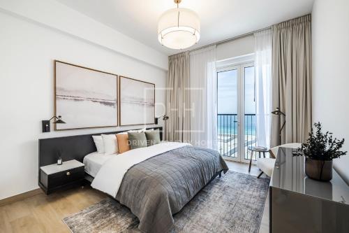 a bedroom with a bed and a large window at Modern 1 Bed Sea View Le Pont B1 La Mer in Dubai