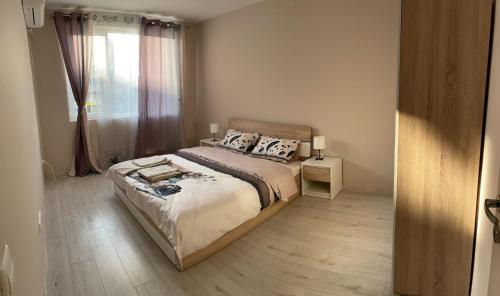 Un dormitorio con una cama grande y una ventana en Apartment Mladost 2 - Free Parking, en Sofía