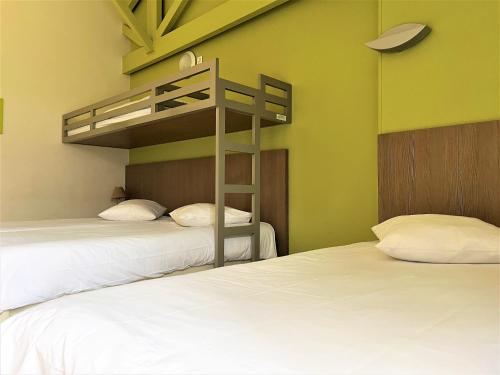 two beds in a room with a bunk bed at Village loisirs de Goule in Bessais-le-Fromental