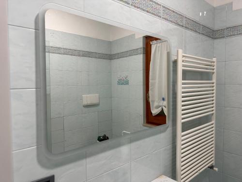 baño blanco con espejo y ducha en Hansel, en Alba Adriatica