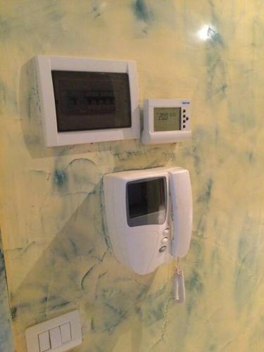 a microwave and a phone on a wall at Casa Vacanze “ Fonte del Borgo” in Lanciano