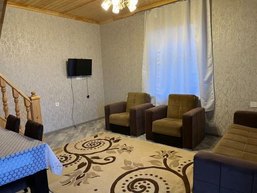 sala de estar con 2 sillas y TV en VILLA MEYSARY, en Şamaxı