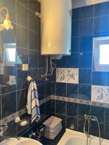 a bathroom with a sink and a blue tiled wall at Skadar Lake Apartment -Karolina in Vranjina