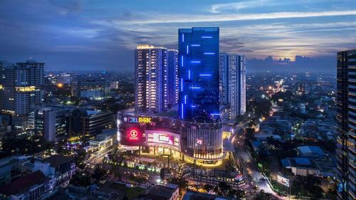 a city skyline at night with a blue building at Apartment Medan Podomoro City Deli by OLS Studio in Medan