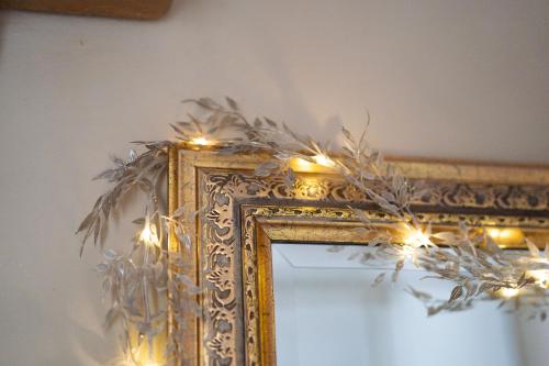 an ornate gold mirror with christmas lights on it at CASA BELGERI - Bed & Breakfast in Dongio