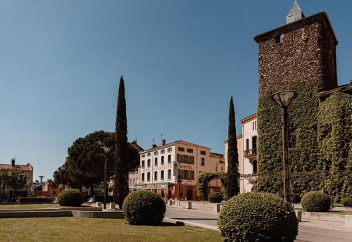 a street with a building and a street light and bushes at Mage hôtels - Hôtel la grenette in Roanne