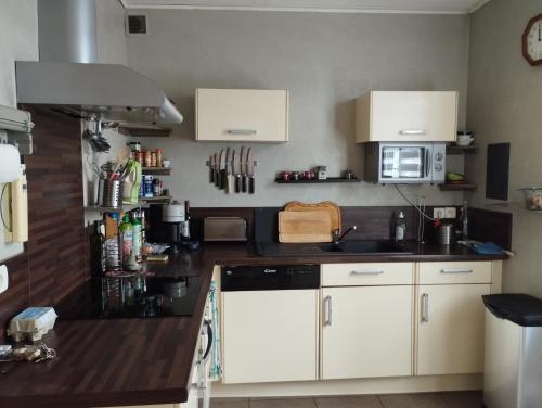 une cuisine avec des armoires blanches et un comptoir dans l'établissement Maison Le Mans, au Mans