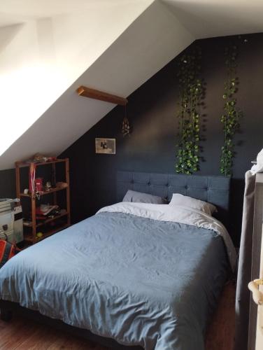 - une chambre dotée d'un lit bleu avec des plantes sur le mur dans l'établissement Maison Le Mans, au Mans