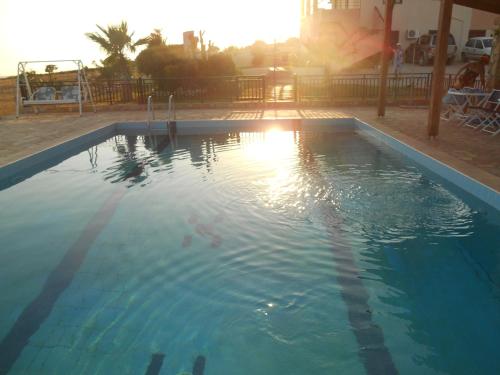 a swimming pool with the sun reflecting in the water at DREAMY SOUTH in Frangokastello