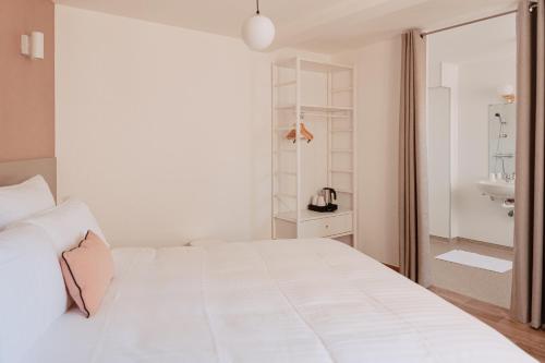 a white bedroom with a white bed and a sink at Mage hôtels - HÔTEL LA GRENETTE in Roanne