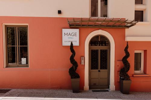 an orange building with a door and a sign on it at Mage hôtels - HÔTEL LA GRENETTE in Roanne
