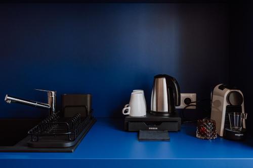 a counter top with a coffee maker and a blender at Mage hôtels - HÔTEL LA GRENETTE in Roanne