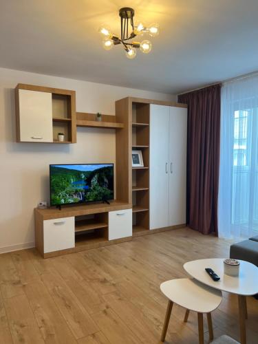 a living room with a flat screen tv and a table at Sunny Apartment in Suceava in Suceava