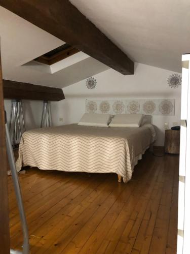 1 dormitorio con 1 cama grande y suelo de madera en L’Eden sur la Colline en Peypin