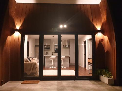 een woonkamer met glazen schuifdeuren en een keuken bij Humble Abode in Auckland