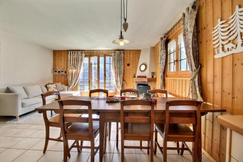 a kitchen and dining room with a wooden table and chairs at Triplex Overlooking The Village - Terrace & Bbq in Champéry