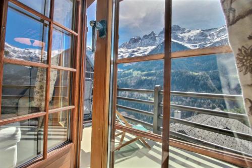 a window with a view of a mountain at Quadze, Overlooking Village, Terrace & Bbq in Champéry