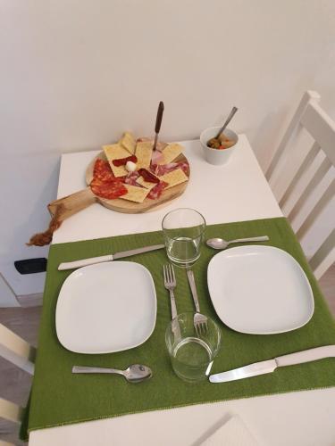 een tafel met witte borden en keukengerei op een tafel bij Il Daviduccio in Catania