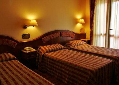 a hotel room with two beds and a window at Hotel Valdaso in Pedaso