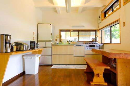 a kitchen with a refrigerator and a wooden table at 四万十川まで歩いて行ける 一棟まるっと貸し切りの宿 gu in Shimanto