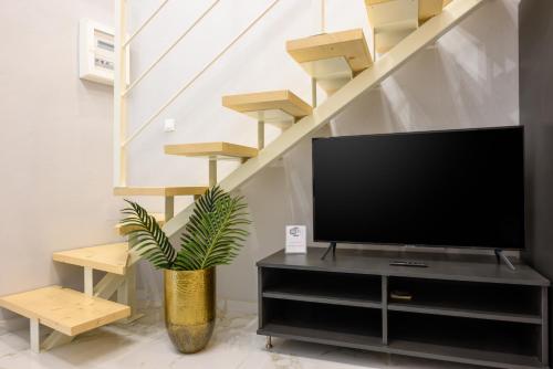 een woonkamer met een flatscreen-tv en een plant bij Nicol studio for two center of Agios Nikolaos in Agios Nikolaos
