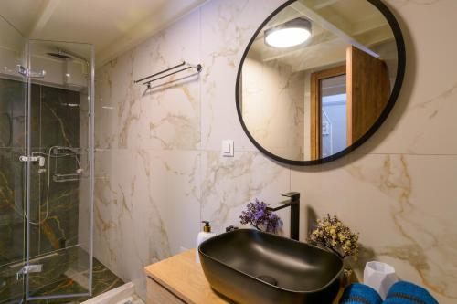 een badkamer met een zwarte wastafel en een spiegel bij Nicol studio for two center of Agios Nikolaos in Agios Nikolaos