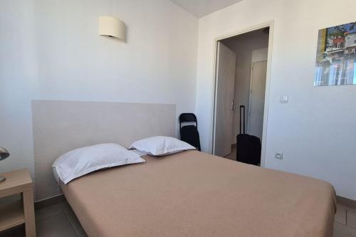 een slaapkamer met een bed met 2 kussens erop bij Studio Cosy a Perpignan Porte Espagne 317 in Perpignan