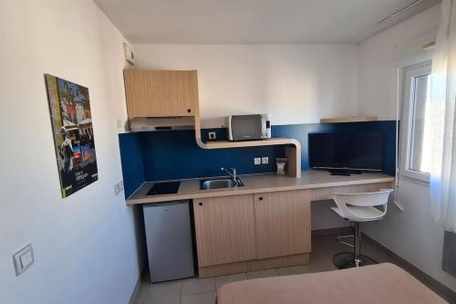 een kleine keuken met een wastafel en een magnetron bij Studio Cosy a Perpignan Porte Espagne 317 in Perpignan