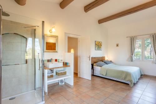 ein Schlafzimmer mit einem Bett, einem Waschbecken und einer Dusche in der Unterkunft LA VILLA DU PETIT BOIS Les Lavandes in Faucon