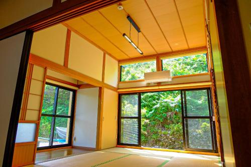an empty room with large windows in a house at 四万十川まで歩いて行ける 一棟まるっと貸し切りの宿 gu in Shimanto