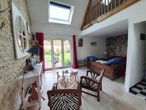 un salon avec un lit, une table et des chaises dans l'établissement Atelier aux Dimes, à Le Manoir