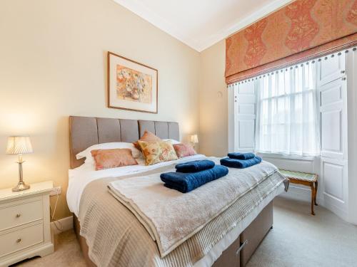 a bedroom with a bed with blue pillows on it at The Anchorage in Pembroke