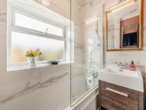 a bathroom with a sink and a shower and a window at The Anchorage in Pembroke