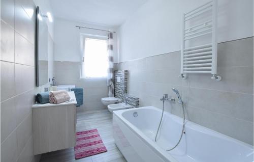 ein weißes Bad mit einer Badewanne und einem WC in der Unterkunft Nonna Maria in Dubino