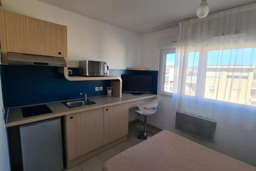 une petite cuisine avec un évier et une fenêtre dans l'établissement 310 Studio Cosy Perpignan Pte Espagne, à Perpignan