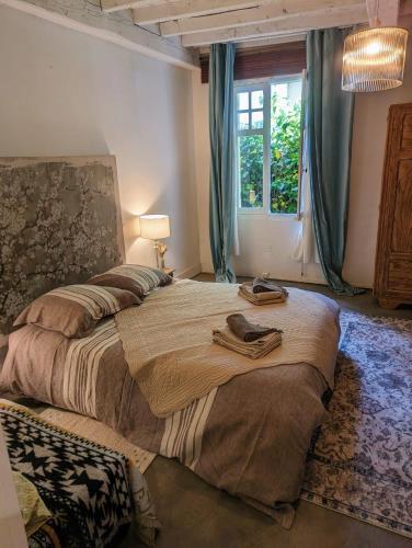 une chambre avec un grand lit et une fenêtre dans l'établissement Maison Pimoli : Chambre Hortense, à Soustons