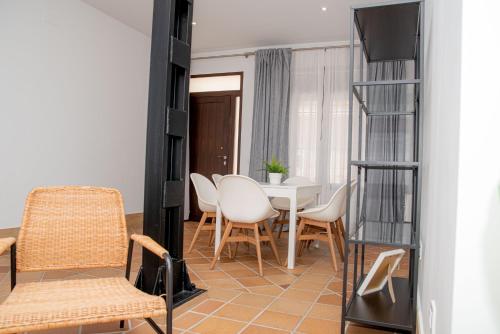 a living room with a table and chairs and a television at Apartamentos Casa Tuli A, ALJARAQUE in Aljaraque