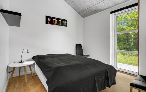 a white bedroom with a bed and a window at Holiday Home Aspevej Grenaa X in Grenå