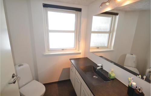 a bathroom with a sink and a toilet and a mirror at Holiday Home Aspevej Grenaa X in Grenå