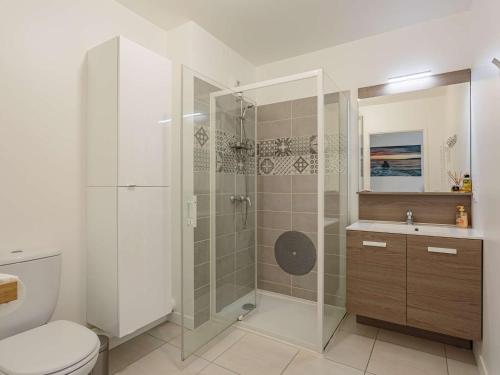 a bathroom with a shower and a toilet and a sink at Appartement moderne à Hendaye, 400m de la plage, terrasse, parking et WiFi inclus - FR-1-2-371 in Hendaye