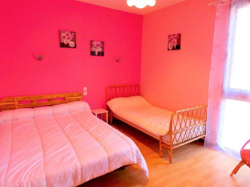 - une chambre avec des murs roses, un lit et une fenêtre dans l'établissement Confortable T2 pour 4 avec parking à St Lary Soulan - FR-1-457-218, à Saint-Lary-Soulan