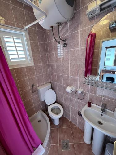 a bathroom with a toilet and a sink at Soko Apartments & Rooms in Zaton