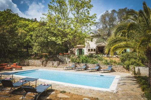 une piscine avec des chaises et une maison dans l'établissement Unique à gassin : 1,5 ha, 4 suites : la campagne au cœur de st tropez, à Gassin