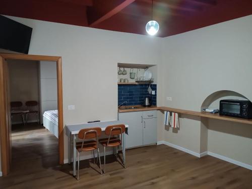 eine Küche mit einem Tisch und 2 Stühlen in einem Zimmer in der Unterkunft 44 Ricci in Anghiari