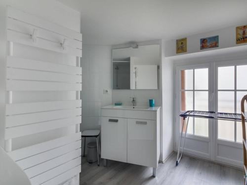 uma casa de banho branca com um lavatório e um espelho em Appartement Cauterets, 3 pièces, 6 personnes - FR-1-401-49 em Cauterets
