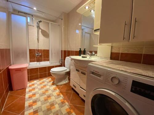 a bathroom with a washing machine and a toilet at Denize 100 mt 2+1 merkezde daire in Alanya
