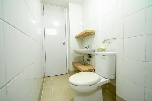 een witte badkamer met een toilet en een wastafel bij Premium 2BR @ Bassura City East Jakarta in Jakarta